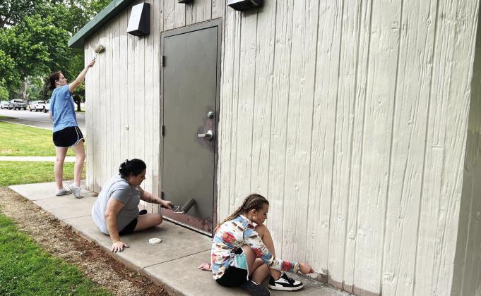 Beaty Baptist youth Ally Poyner (far left) and Kaitlyn Johnson (right), along with church member Jessica Annen, worked to paint restroom buildings at Wacker Park Saturday. The youth group also worked on other projects around town as part of a community mission weekend, including picking up trash, repairing park benches and replacing a wheelchair ramp for a local resident. News Star photo by Suzanne Mackey
