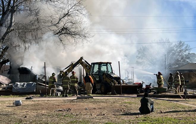 Pauls Valley firefighters used heavy equipment to remove parts of the burned out structure at 105 Madison St. as they worked to extinguish the fire. News Star photo by Suzanne Mackey